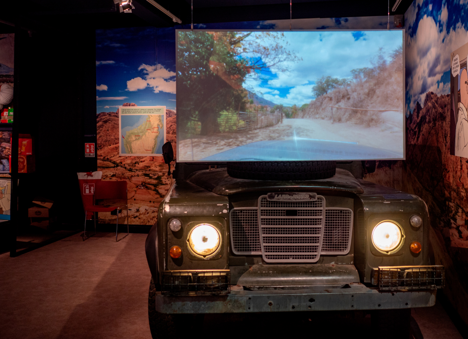 Grand écran placé sur le capot d'un 4x4 en plein cœur d'une salle d'exposition